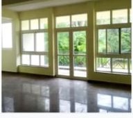 ISI Guest House — lounge with French windows overlooking gardens